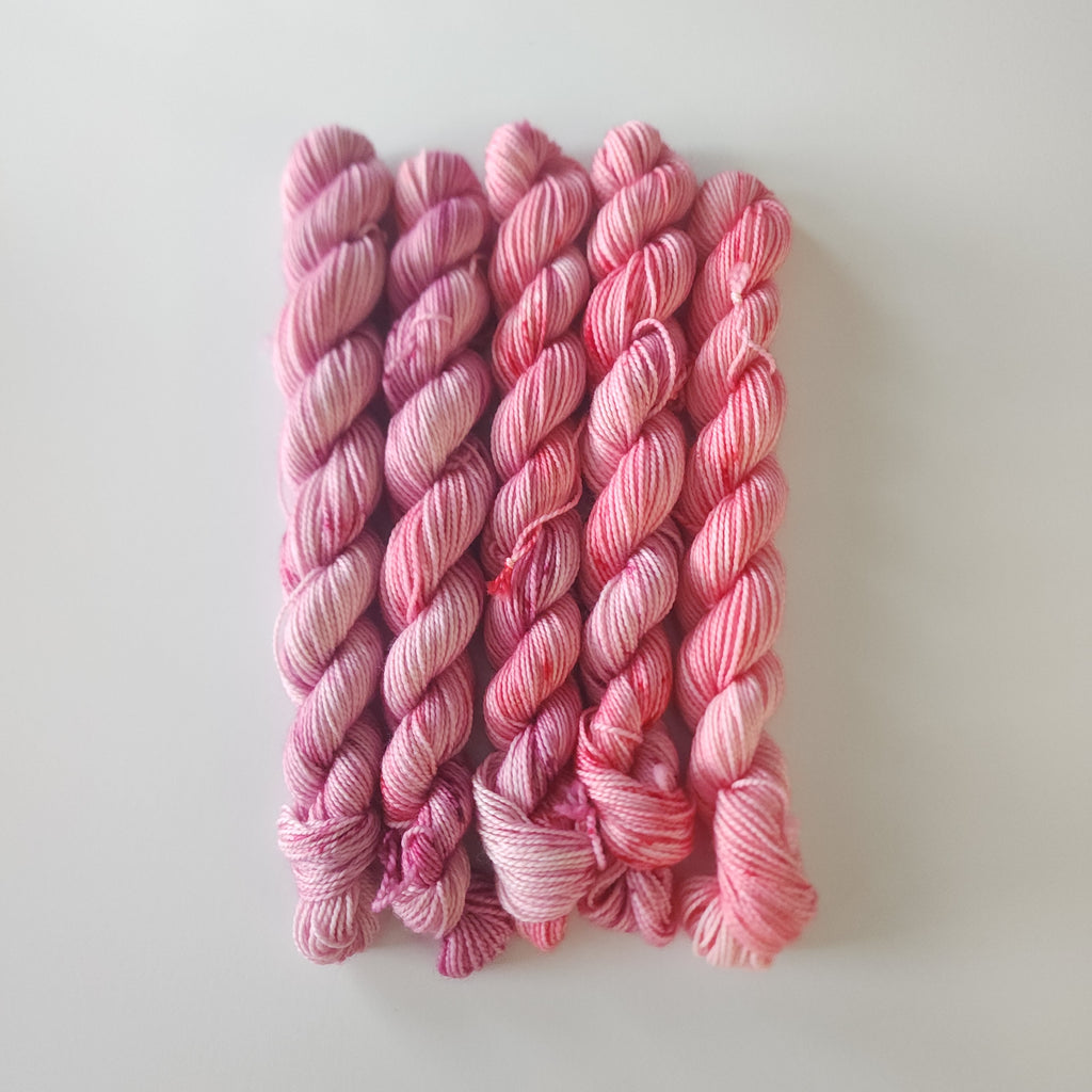 Stack of pink yarn on a white background